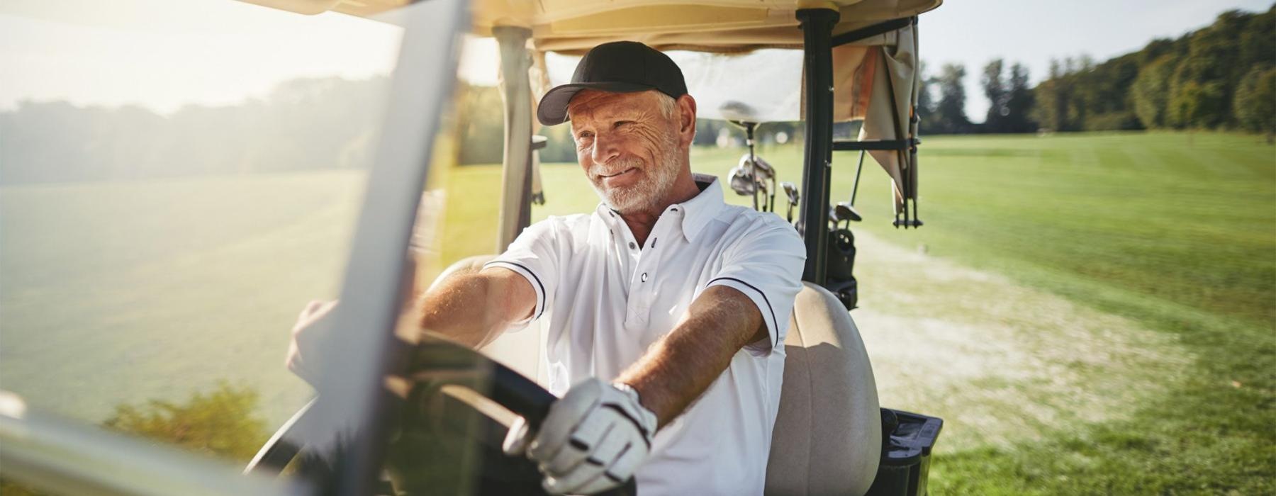 a man driving a golf cart