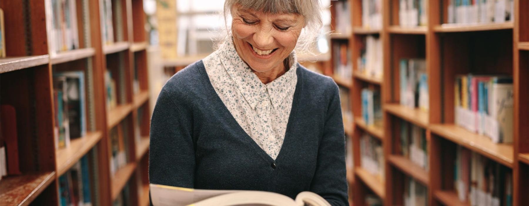 a woman reading a book in a library