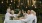 a group of people sitting at a table with food